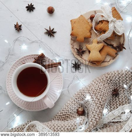 A cup of tea and Christmas cake surrounded by Christmas lights on the table for the Christmas celebration