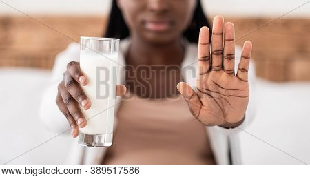 Unrecognizable Black Pregnant Lady Rejecting Glass Of Milk, Showing Stop Gesture At Camera, Sufferin