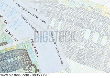 10 Croatian Kuna Bills Lies In Stack On Background Of Big Semi-transparent Banknote. Abstract Busine