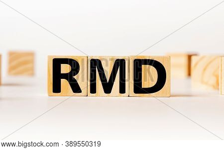 A Wooden Block With The Word Rmd Required Minimum Distributions Written On It On A White Background.