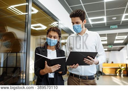 Businesspeople Discuss Workring Issues During Pandemic Of Coronavirus. Man And Woman Wearing Protect