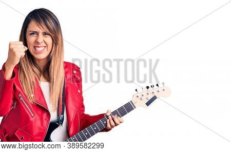 Young beautiful woman playing electric guitar annoyed and frustrated shouting with anger, yelling crazy with anger and hand raised 