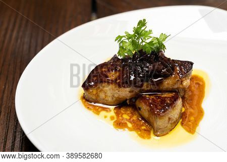 Grilled Foie gras, grilled duck and goose live poultry, with plum savoury sauce. Gourmet international cuisine recipe using for buffet food and drink concept.