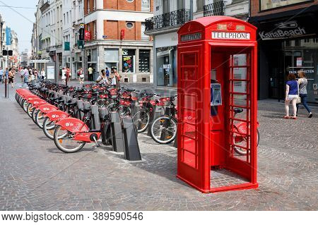Lille, France - July 18, 2013. Red British Telephone Box And Free Bike Rental Station In A Street In