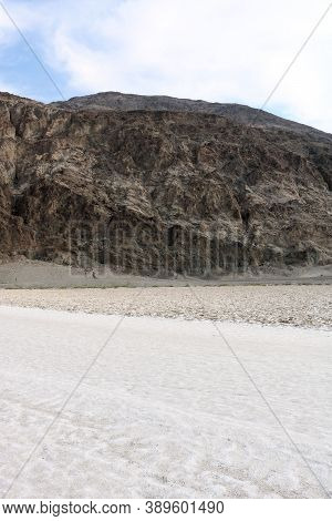 Arid Dry Lakebed On Salt Flats With Barren Mountains Beyond Taken At Badwater Dry Lake In Death Vall