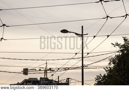 Yellow Metal Crane In Front Of A Building Being Assembled In A Construction Site Taken From Far Away