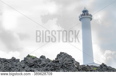 Cape Zanpa Lighthousewith Surrounding Volcanic Rock Formation And Silver Line Sky With Grey Clouds