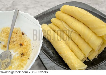 Rolled Maida Dosa With Sweetened Grated Coconut In A Plate Alongwith A Bowl Of Coconut Beside. Keral