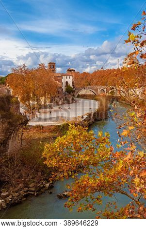 Autumn And Foliage Along River Tiber. Beautiful Red, Orange And Yellow Leaves Near Tiber Island In R
