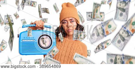 Young beautiful mixed race woman holding vintage radio thinking attitude and sober expression looking self confident