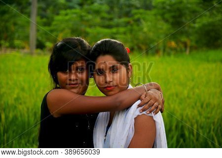 Close  Of  Two  Teenage Girls Wearing Colorful Indian Dresses Of Salwar Kameez In A Green Paddy Fiel
