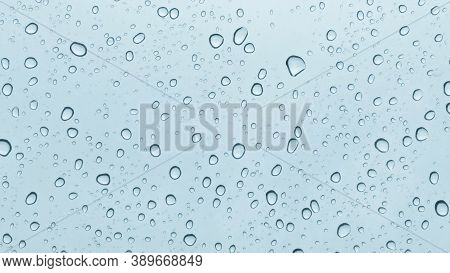 Blurred Many Rain Drops On A Car Window With Blue Tone Condition Background In Rainy Day