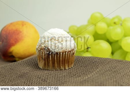 Fresh Muffin Sprinkled With Powdered Sugar. Background For Text. Fresh Fruit Muffin And Fruit