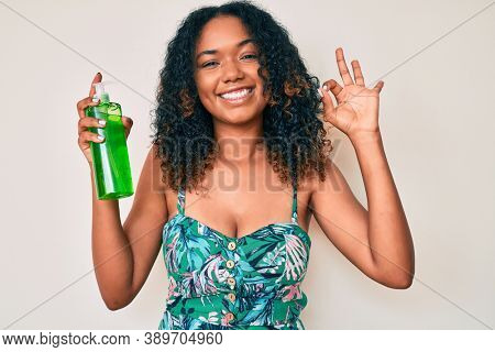 Young african american woman holding aloe vera doing ok sign with fingers, smiling friendly gesturing excellent symbol 
