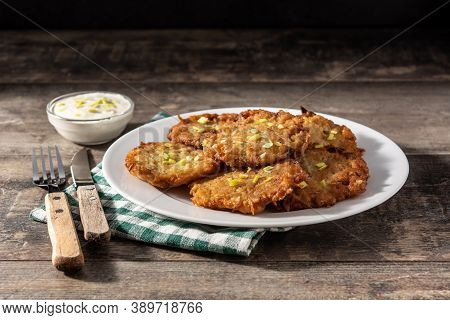 Traditional Jewish Latkes Or Potato Pancakes On Wooden Table