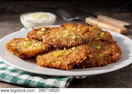 Traditional Jewish Latkes Or Potato Pancakes On Wooden Table