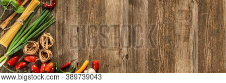 Italian food background with raw pasta and vegetables