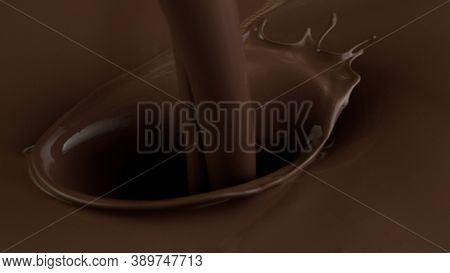 Detail of pouring hot chcocolate with splash. Studio macro shot.