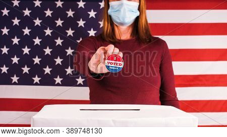 Voting Woman With Face Mask Showing I Voted Today Button At 2020 American Presidential Elections.