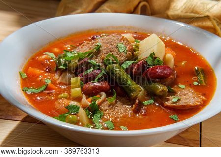 Hearty Italian Minestrone Soup With Sliced Sausage And Vegetables