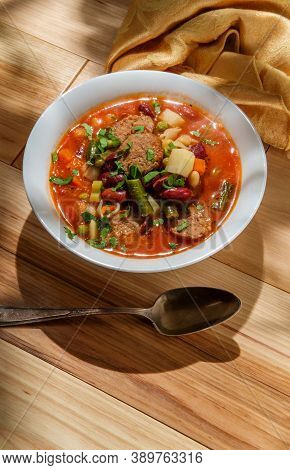 Hearty Italian Minestrone Soup With Sliced Sausage And Vegetables