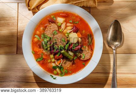 Hearty Italian Minestrone Soup With Sliced Sausage And Vegetables