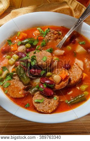 Hearty Italian Minestrone Soup With Sliced Sausage And Vegetables