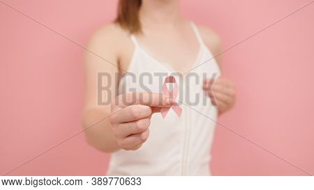 Pnk October, Brest Cancer Awareness Ribbon In The Hand Of A Young Unrecognzable Woman. High Quality 
