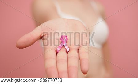 Pnk October, Brest Cancer Awareness Ribbon In The Hand Of A Young Unrecognzable Woman. High Quality 