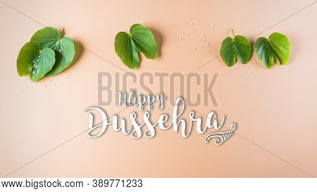 Happy Dussehra. Green Leaf On Orange Pastel Background. Dussehra Indian Festival Concept.