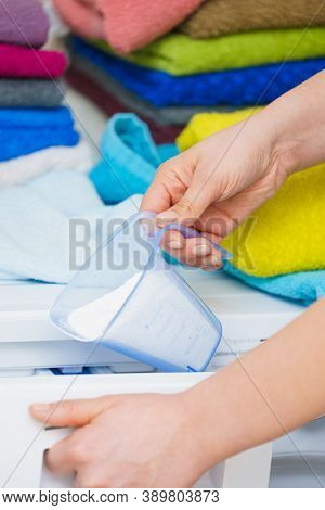 Washing Powder Detergent And Measuring Cup Pouring Into Machine. Household Duties, Clothes Laundry O