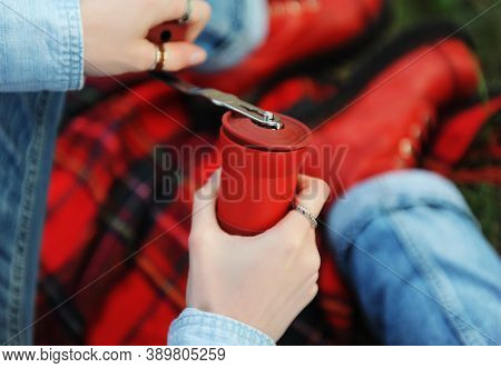 Coffee Outdoor Aesthetic. Red Manual Grinder In Hands Closeup. Red Boots, Checkered Plaid In Autumn 