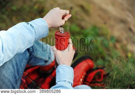 Coffee Outdoor Aesthetic. Red Manual Grinder In Hands Closeup. Red Boots, Checkered Plaid In Autumn 