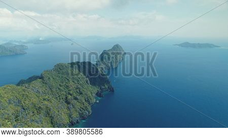 Tropical highland island aerial view at blue ocean bay. Asia mountainous isle with exotic nature variety scape. Cinematic summer scenery of Palawan islet, Philippines. Soft light drone shot