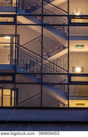 Empty Stairwell With Staircase Illuminated Inside Modern Housing Block Viewed From Outside Through G