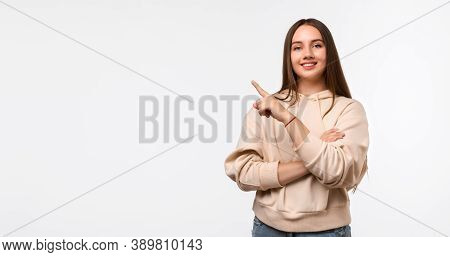 Happy Pretty Young Woman With Long Chestnut Hair, Pointing Finger To The Side, Shows Copy Space For 