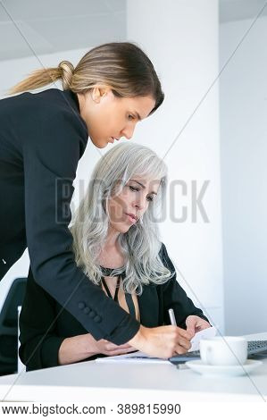 Project Manager Standing Near Employee, Writing Notes In Document Or Affixing Signature On Paper Rep