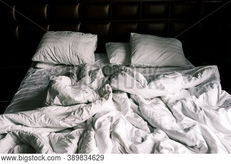 Unmade Double Empty Bed With White Linens. Sheets And Pillows In The Apartment Or Hotel After A Nigh