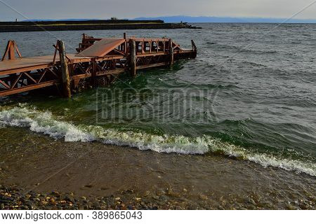 Old Rusty Iron Pier, Red Orange Bright Dock Construction On Sandy Stone Shore Of Lake Baikal In Gree
