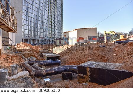 Laying Heating Pipes In A Trench At Construction Site. Install Underground Storm Systems Of Water Ma
