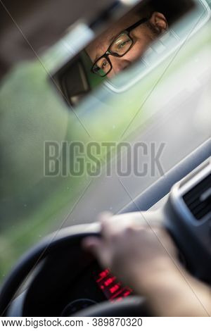 Handsome young driver driving hic car fast yet safely on the road