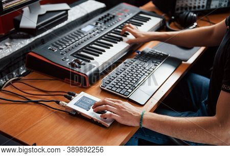 Playing Midi Keyboard. Sound Engineer Working And Mixing Music Indoors In The Studio.