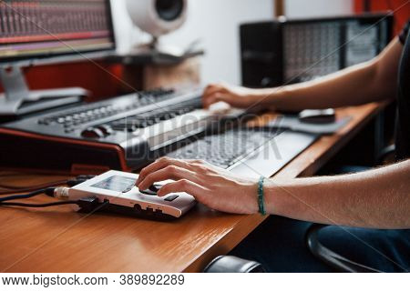 Playing Midi Keyboard. Sound Engineer Working And Mixing Music Indoors In The Studio.