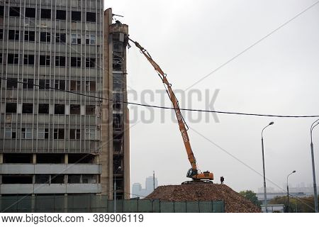 Moscow / Russia - October 13 2020: A Very Long Boom Excavator Destroys A High-rise Building. Demolit