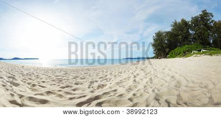 Panorama of a tropical beach with white sand and green trees on the coast. Bang Tao beach of Phuket island, Thailand