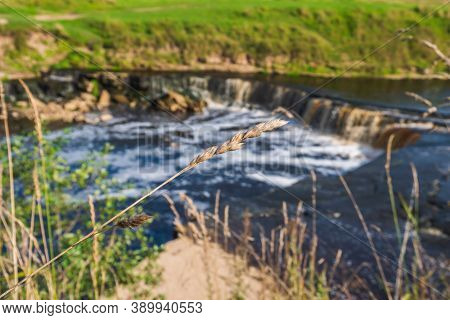 Waterfall, Water Flowing From The River Falls Down. A Stormy River With A Brown Hue.