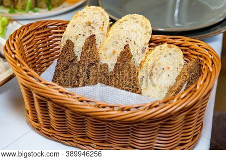 Black And White Bread In A Basket. Sliced ??bread In A Basket. Pieces Of Bread Are Ready To Eat