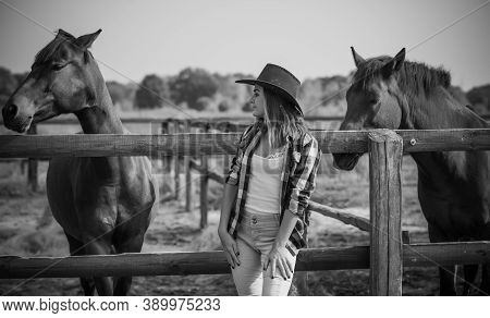 American Woman On A Horse Farm. Portrait Of Girl In Cowboy Hat With A Horses. Hippotherapy At Nature