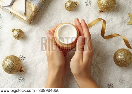 Female Hands Hold Jar Of Cosmetic Cream On Background With Christmas Accessories
