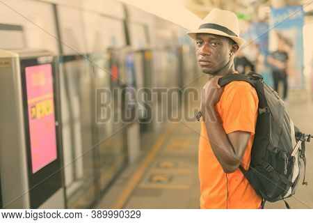 Young Black African Tourist Man Waiting For The Train At Bts Sky Train Station Of Bangkok Thailand